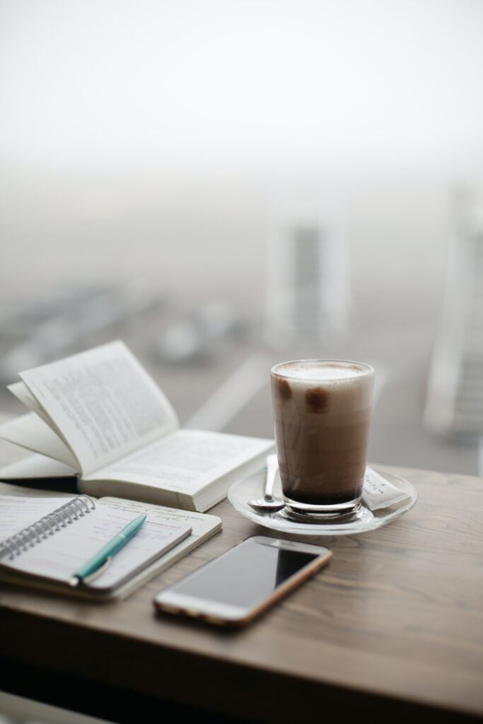 An open book placed next to a steaming cup of coffee, creating a tranquil morning scene for writing blog with images